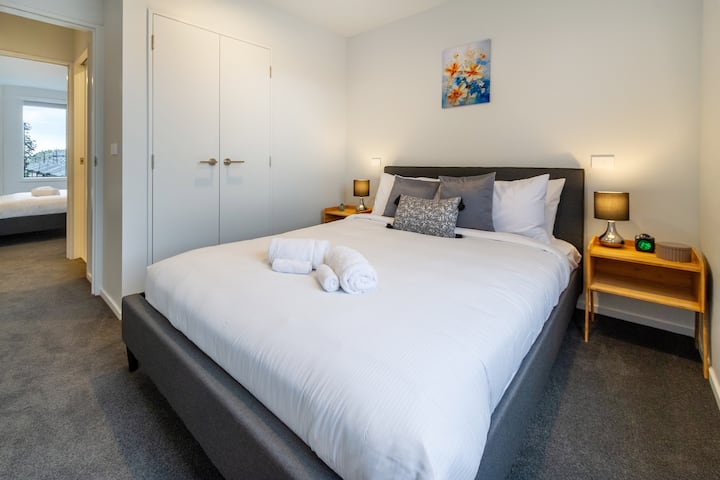 Dormitorio acogedor y minimalista con sábanas blancas frescas y una manta suave.