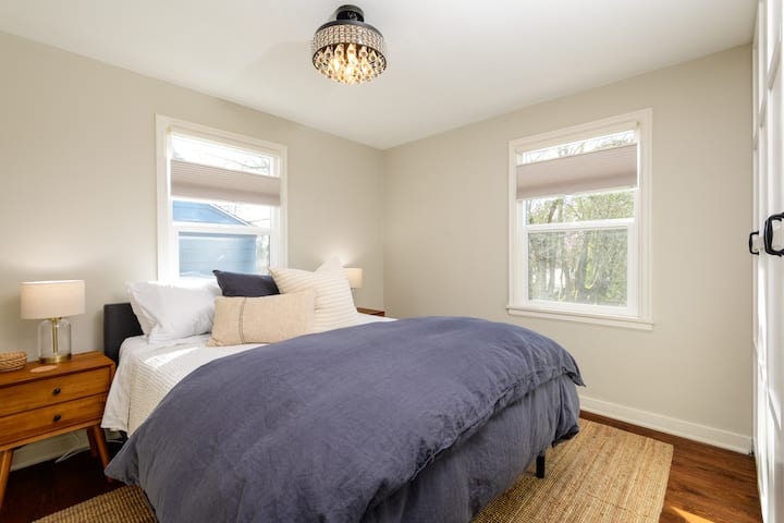 غرفة نوم في الطابق الرئيسي بسرير كبير وظلال خصوصية وخزانة ملابس.