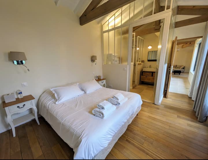 Основна къща: 1-ва главна спалня от 14 м² (двойно легло 160x200), с гардероби - гардероб, и нейната душ стая и тоалетна, с изглед към градината.