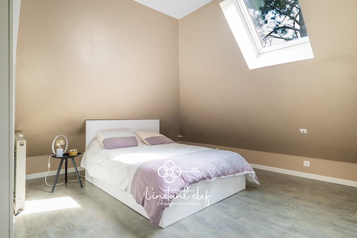 Repos sous la lumière naturelle – Une chambre cosy aux tons doux, baignée de lumière grâce à une grande fenêtre de toit.