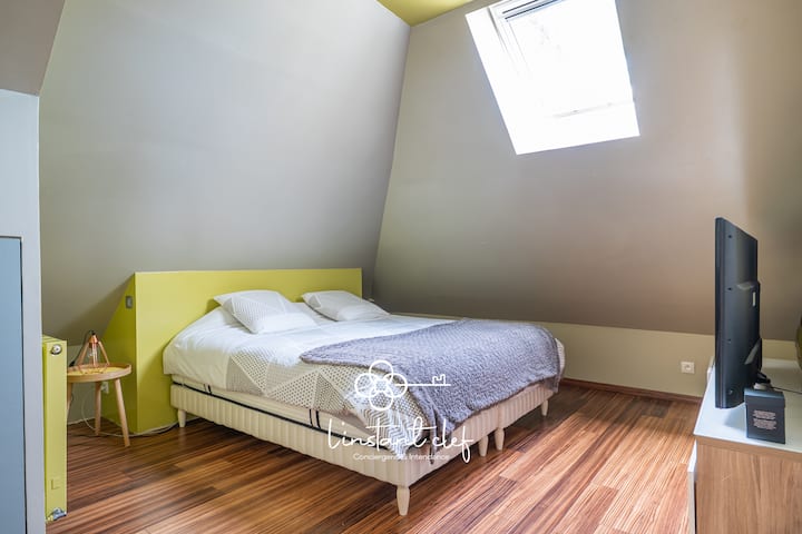 Chambre cosy sous les toits – Un lit double confortable et une belle luminosité naturelle pour des nuits paisibles.