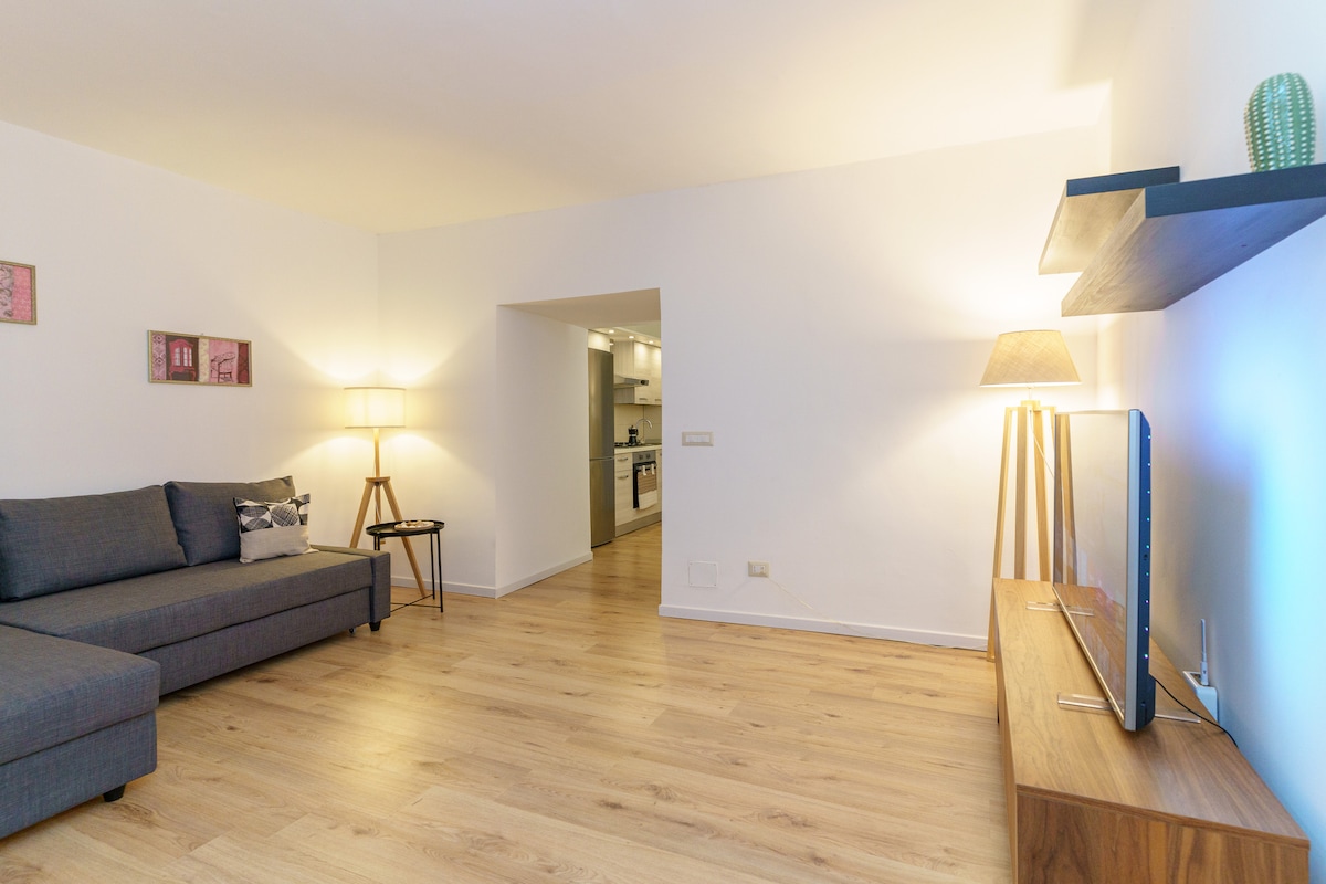 Всекидневна с голям и модерен разтегателен диван и смарт телевизор