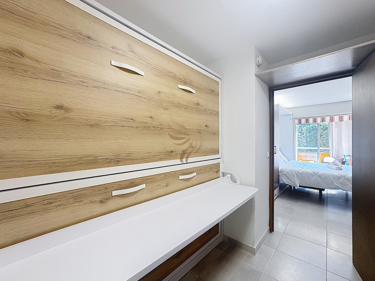 Entrada moderna con mesa oculta en la pared de madera. Imagina un espacio práctico donde relajarte y planificar tus aventuras en el corazón de tu estadía.