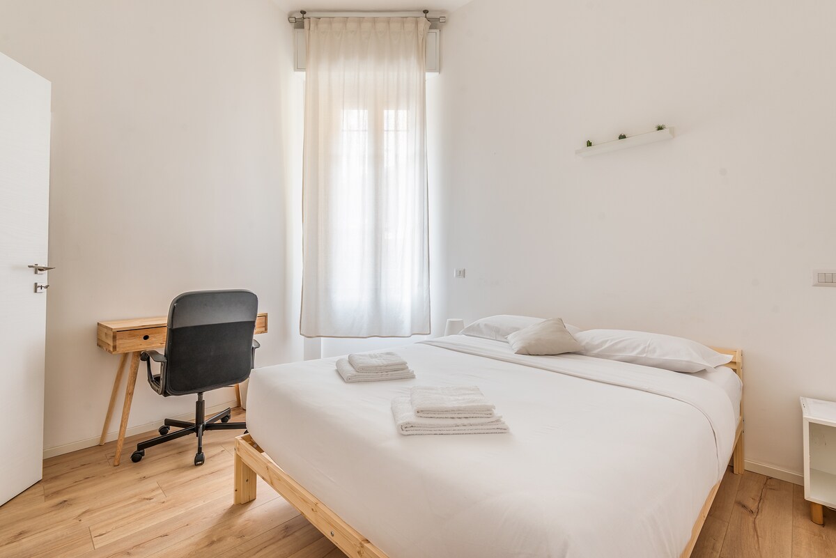 Eerste slaapkamer met tweepersoonsbed, hoog en comfortabel matras, bureau, kleding ophangen. Beddengoed en handdoeken zijn inbegrepen