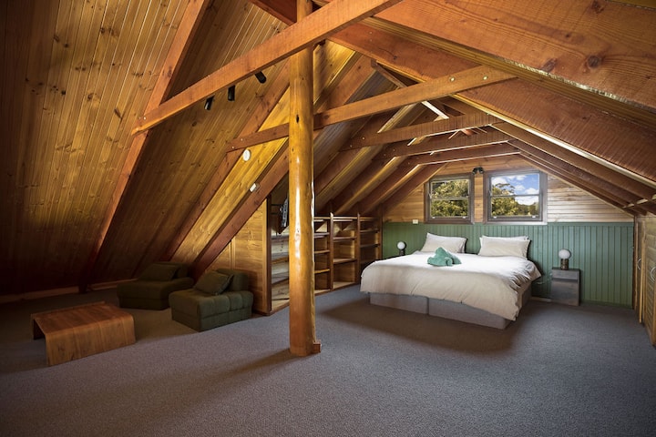 Dormitorio loft con zona de estar, mucho espacio de almacenamiento, persianas romanas y TV inteligente