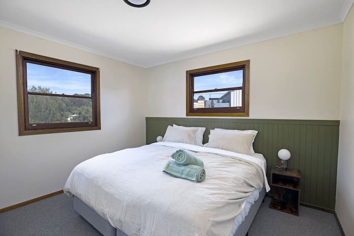 Habitación privada con cama tamaño king, persianas romanas, bata incorporada y vistas al césped