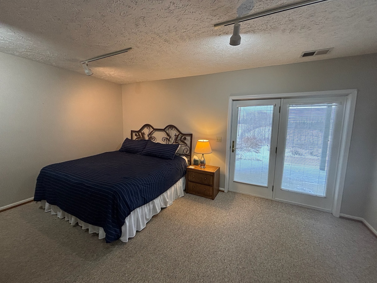 Spálňa s manželskou posteľou King na dolnom poschodí s prístupom na terasu