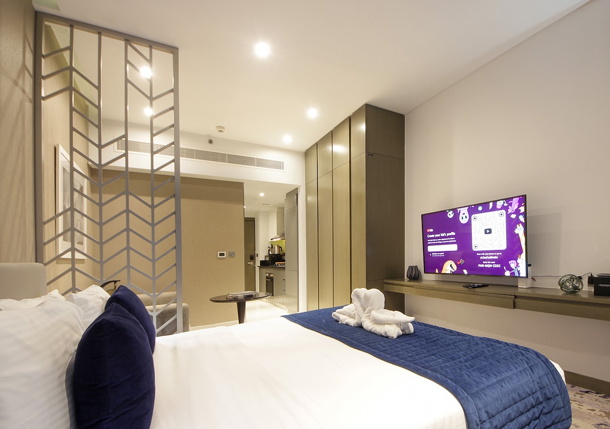 Влезте в спалнята, където спретнато подреденото легло в студиото създава спокойна обстановка за почивка по време на престоя ви. Естествената светлина през прозорците и приветливото оформление подпомагат тихите вечери и спокойния сън след цял ден в Дубай.