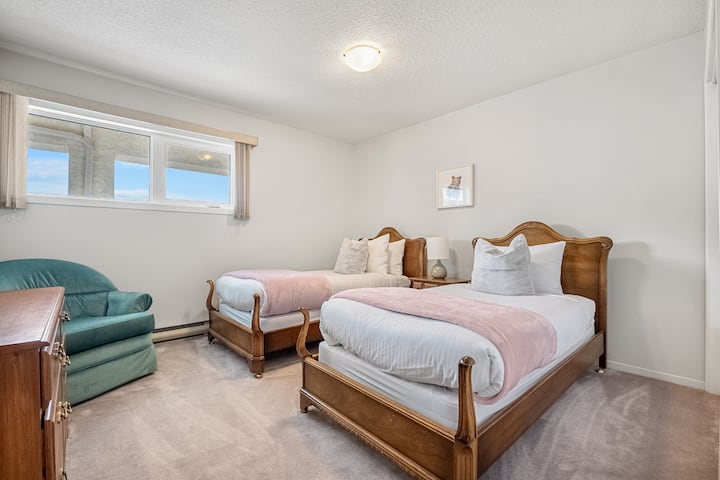 Chumba cha kulala cha tatu chenye vitanda viwili (2), kabati na vivuli vinavyofanya chumba kiwe na giza.