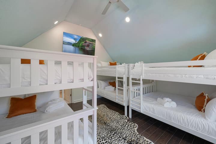 The ultimate sleepover space! ‍♀️ This vaulted bunk room sleeps 12 with 6 queen beds, a 65" Smart TV, and stylish vibes. Perfect for bachelorettes, retreats, or big families—everyone gets their own cozy corner to crash! 