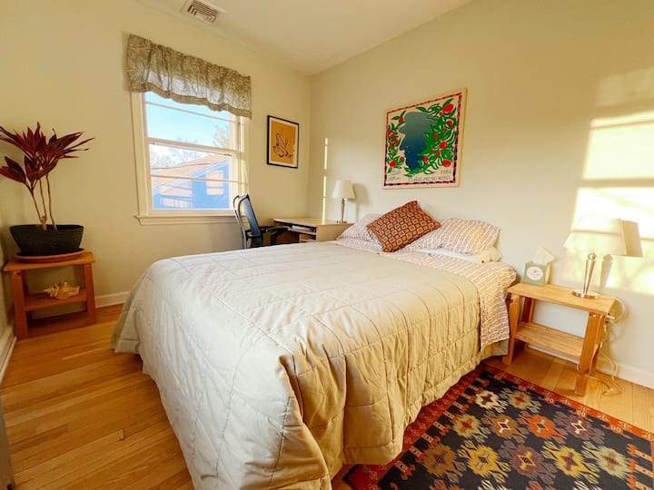 配备全尺寸床和书桌的松木卧室