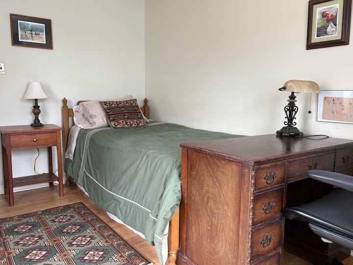 核桃木卧室，配有双人床和书桌