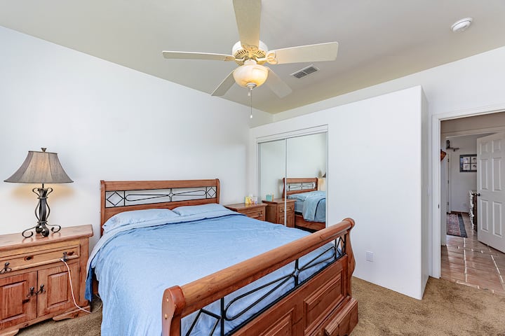 Acogedora cama tamaño queen con armario corredizo con espejos en el dormitorio 1.