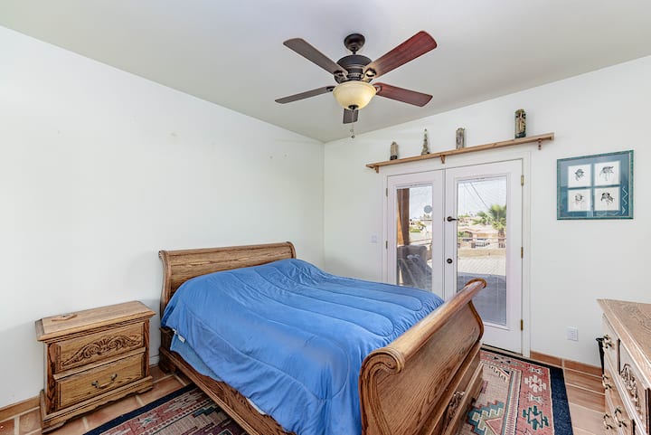 Acogedora cama tamaño queen, puertas de armario con espejos y acceso al aire libre a través de puertas francesas.