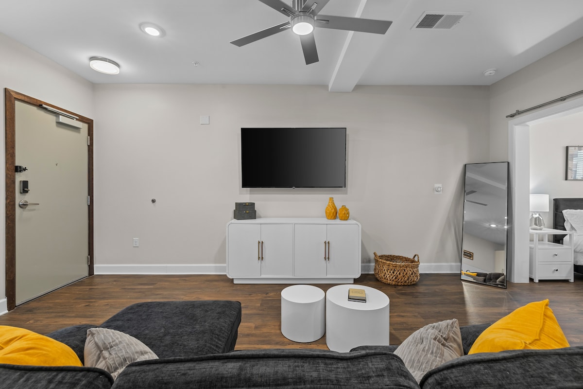 - Sala de estar luminosa con TV y decoración moderna para una estancia cómoda.  
- Diseño limpio con suelos de madera y asientos acogedores para relajarse.  
- Espacio ideal de Airbnb con fácil acceso a todas las habitaciones  