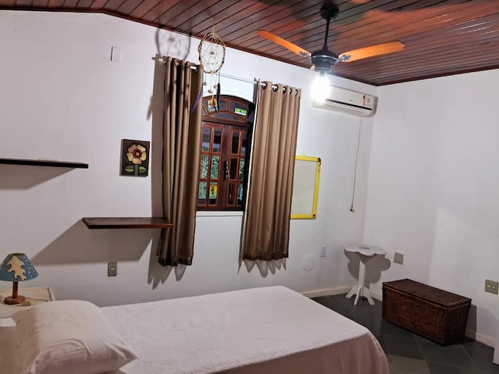 Спалня с баня, климатик и вентилатор на тавана. 