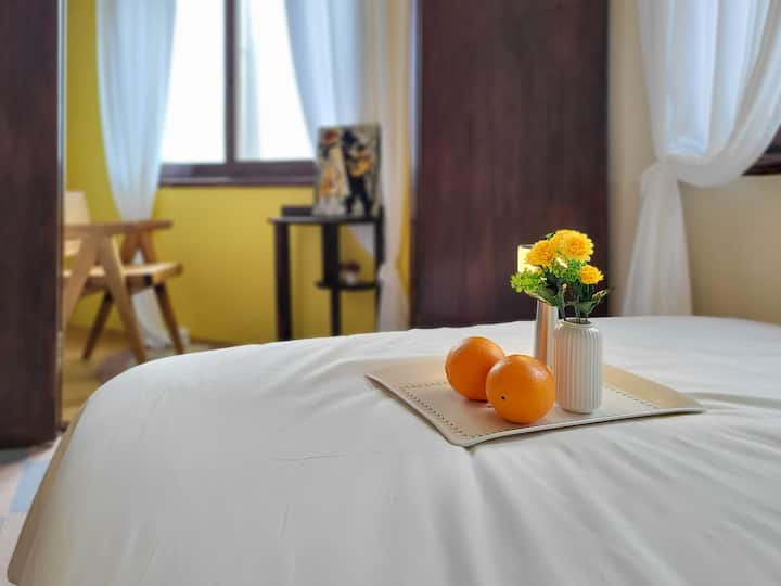 1 lit Queen Size et une chambre latérale (chaise, peinture, table d'appoint)