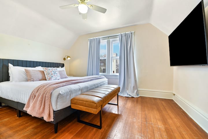 The Master bedroom features a walk-in closet, 65" TV, blackout curtains, fresh, clean linens, extra pillows and blankets, a roll-away bed and comfortable chair to sit and relax.