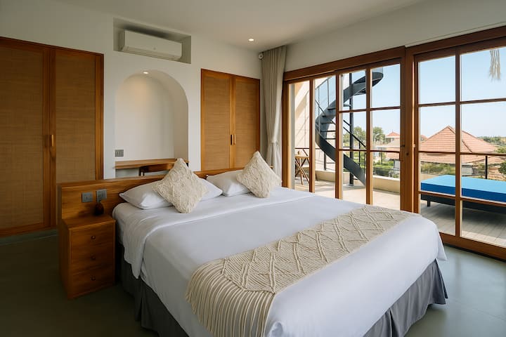 تتميز غرفة النوم الرئيسية، المشرقة والهادئة، بسرير بحجم كينج، وإضاءة طبيعية، وتشطيبات خشبية، وإمكانية الوصول المباشر إلى التراس. ملاذ هادئ للاستيقاظ على نسيم المحيط.