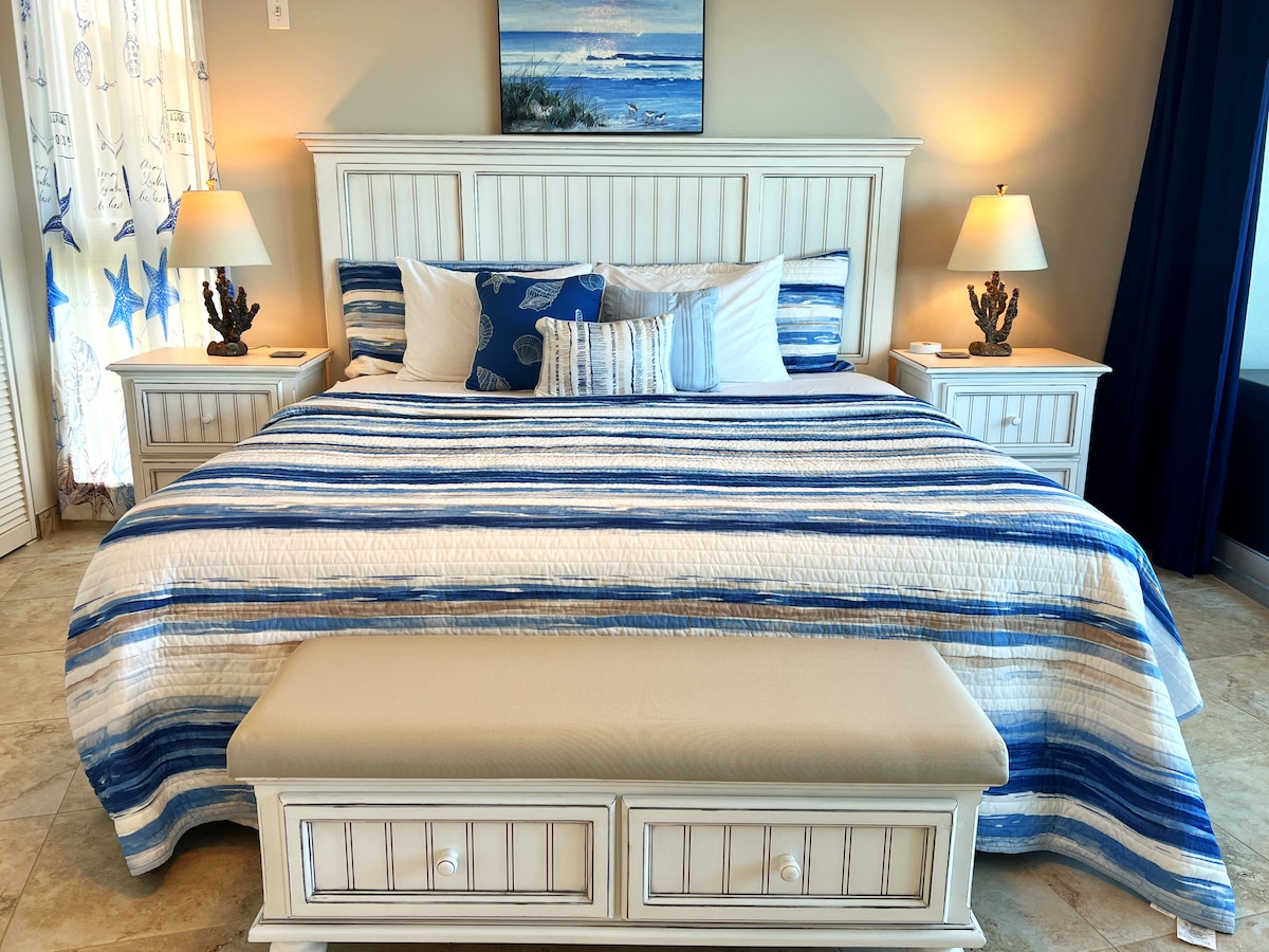 Táto spálňa je štýlová a príjemná a kombinuje pohodlie s premyslenými detailmi, ako sú rohový stolík a lampa.