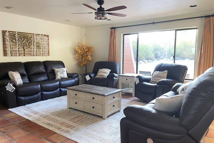 Cómoda sala de estar con sillones de cuero nuevos, televisor inteligente Roku de 50", juegos de mesa en el armario de la chimenea, chimenea y ventilador. 