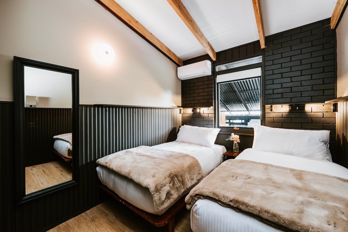 Четвъртата спалня също предлага подобен стил с две двойни единични легла, идеални за спокойна пауза между дегустацията на вино и събиранията край камината.