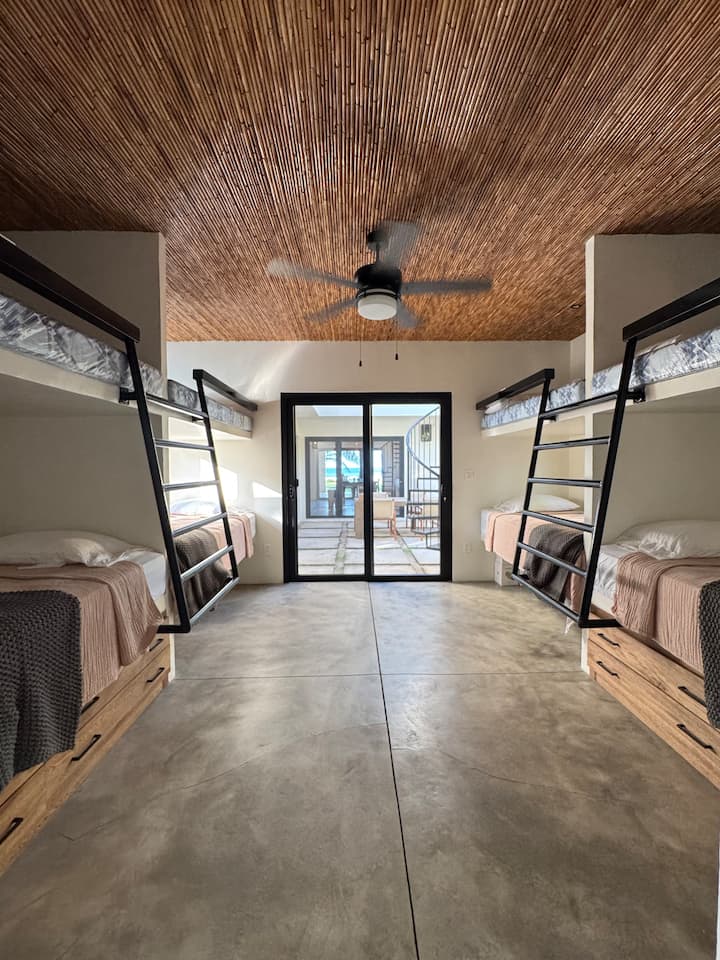 Chumba cha ghorofa kilicho na vitanda 8 vya ukubwa wa mapacha. Kila kitanda kina kituo chake cha kuchaji kwa ajili ya vifaa. 