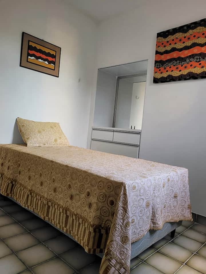 Dormitorio con cama individual conjugada, ventilador, cómoda y armario