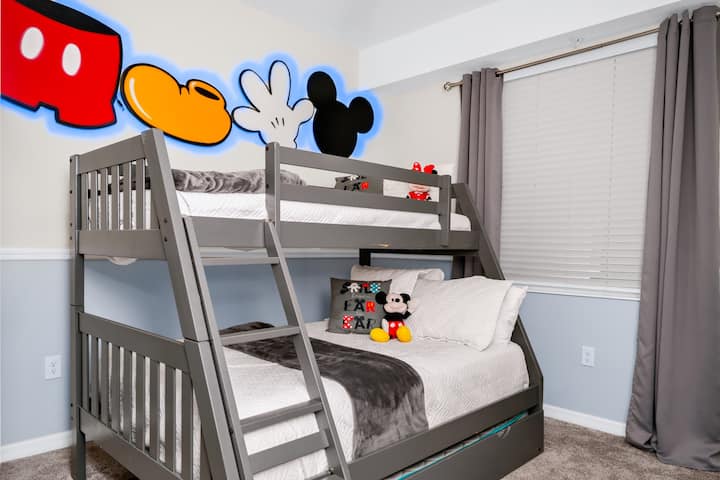 Habitación temática de Disney con una litera que incluye 1 cama doble en la litera inferior con una cama nido extraíble y 1 cama individual en la parte superior