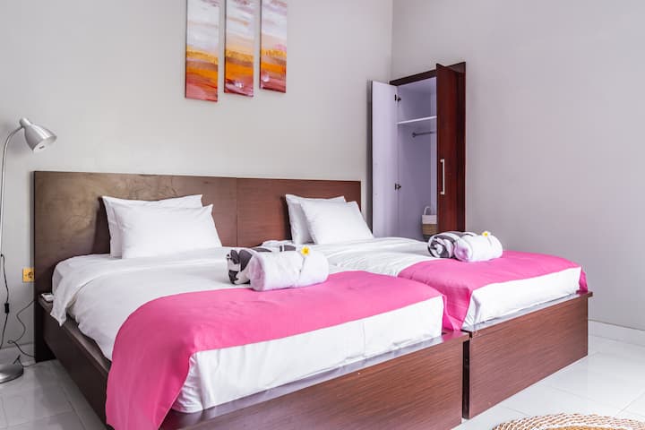 Twin bedroom with closet and bedside lamp