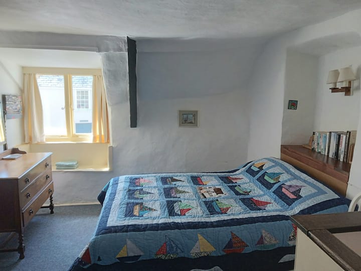 De ruime hoofdslaapkamer heeft een ladekast en een kledingkast.  De patchworkquilt in deze kamer is speciaal voor Dolphin Cottage gemaakt door je host.  