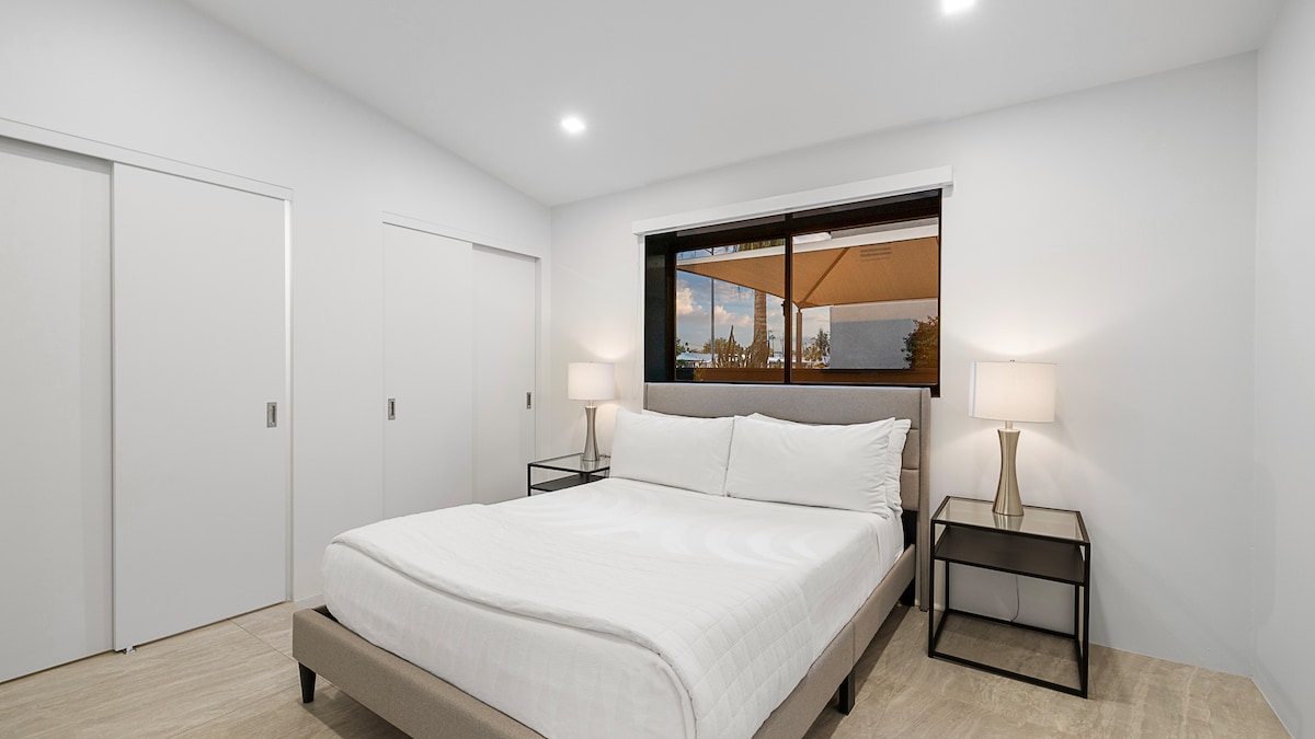 კომფორტული, თანამედროვე საძინებელი 150‑179 სმ ზომის საწოლით, რბილი განათებითა და ფანჯრიდან პატიოს ხედით.