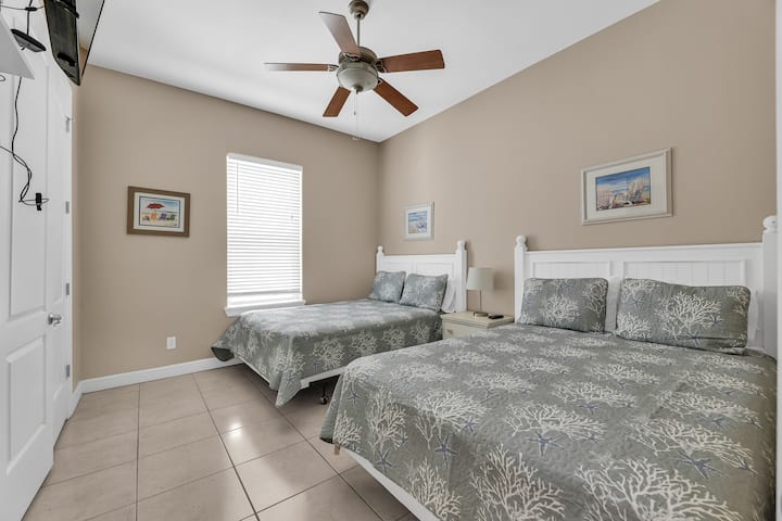 Chumba cha Kulala cha Malkia: Chumba cha kulala kinachovutia chenye vitanda viwili vya malkia na mapambo yaliyohamasishwa na ufukwe. 