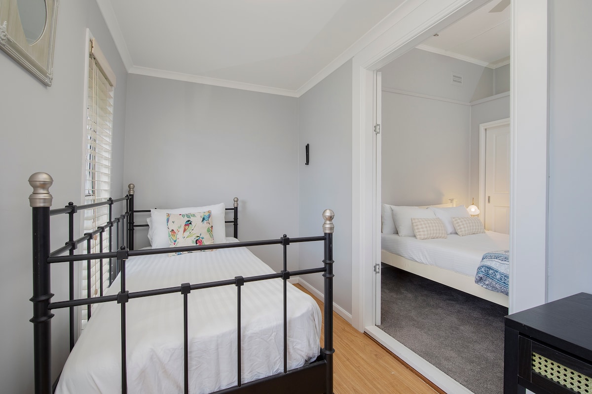 Pata starehe inayoweza kubadilika katika chumba cha kulala cha tatu, kamili na kitanda cha kifahari na sehemu moja iliyo karibu kwa ajili ya familia au marafiki wanaoshiriki sehemu hiyo.