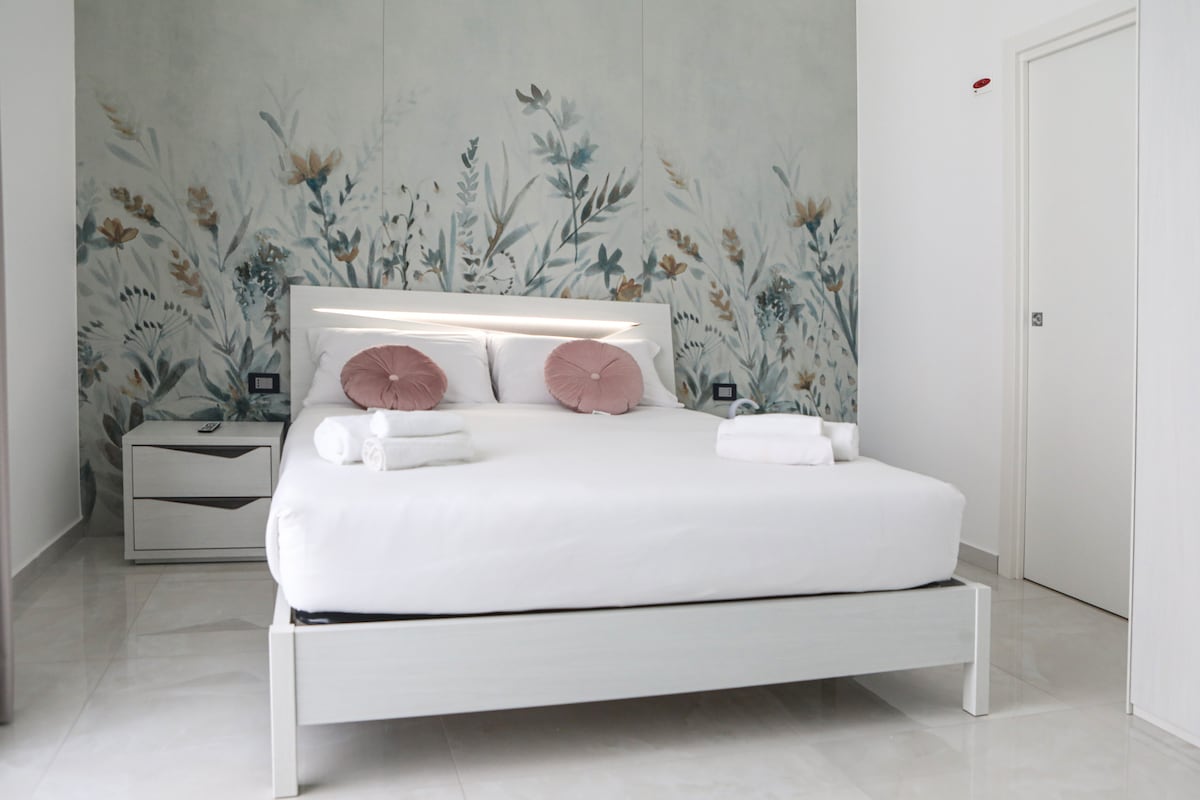 Стая Chiaia: просторна и елегантна, с голямо двойно легло, релаксиращ диван, пудра и градински чай, смарт телевизор с Netflix, Wi - Fi, климатик и минибар. Изискана и романтична обстановка, идеална за бягство в сърцето на Неапол 