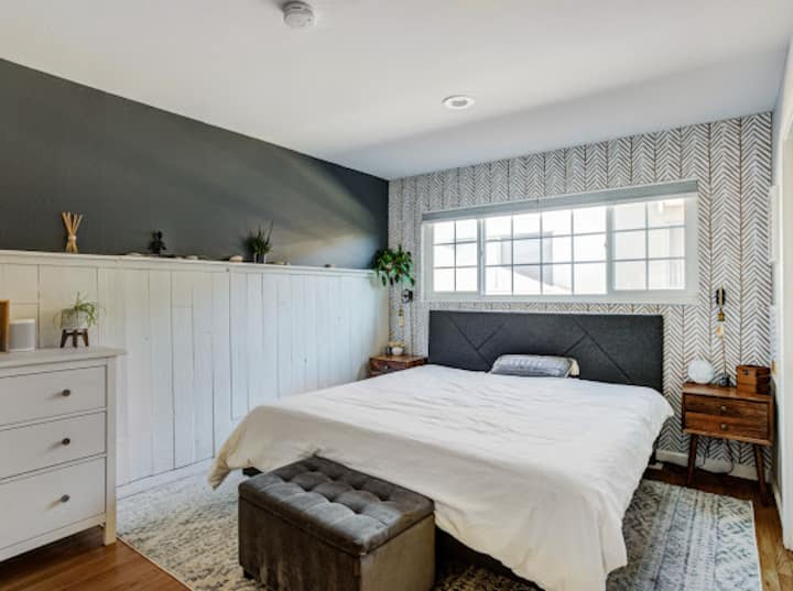 Vue de la chambre avec lit king, placard double, stores et salle de bain privée