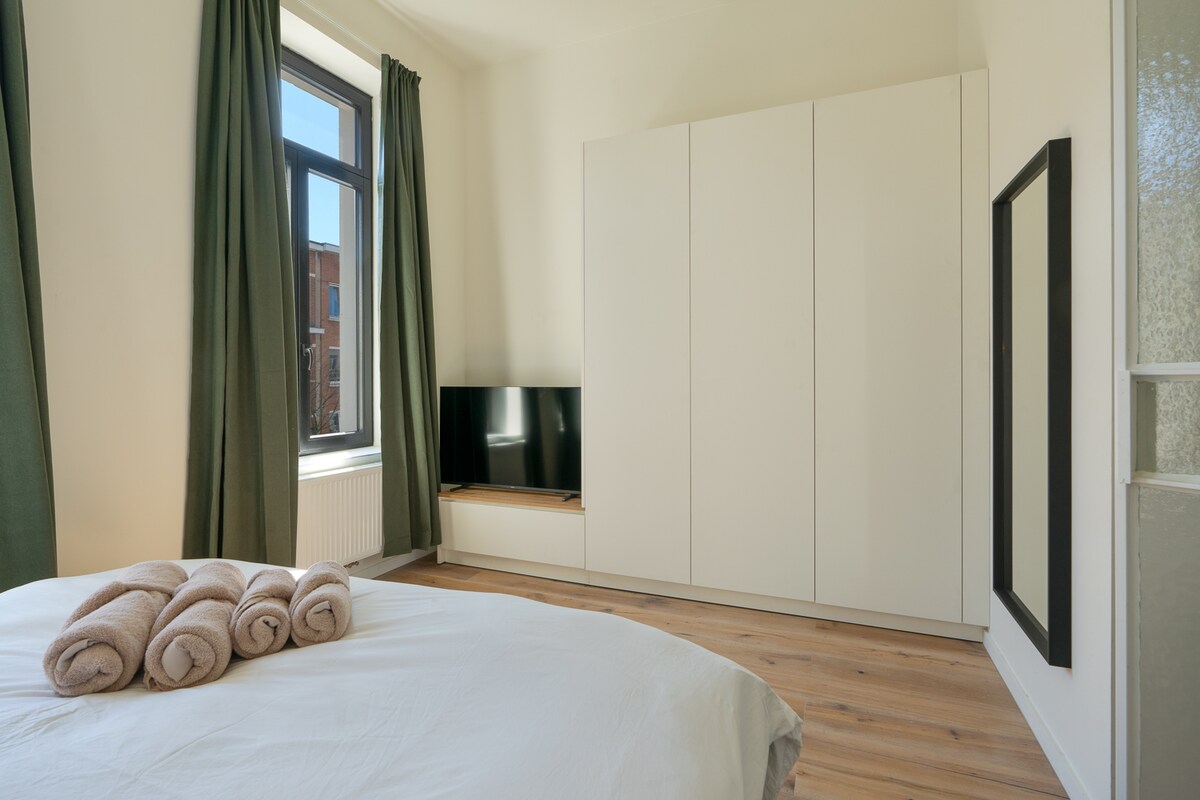 - Relájate en una habitación serena con sábanas limpias, toallas acogedoras y luz natural cálida.
- Un montón de espacio de almacenamiento, un televisor de pantalla plana y cortinas opacas hacen que la comodidad sea fácil.
- Ya sea al amanecer o por la noche de cine, esta habitación está diseñada para una relajación total.