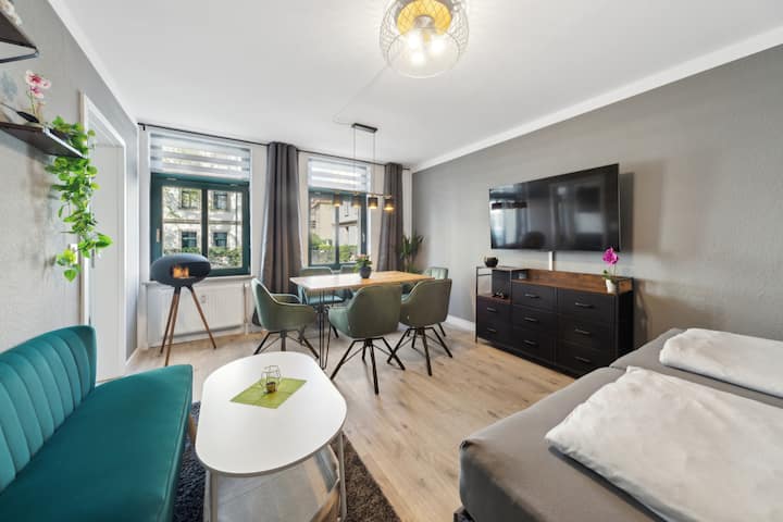 Sala de estar con 2 camas completas de 90x200 cm, que también se pueden juntar para formar una doble. Una mesa con seis sillas giratorias. Un pequeño sofá con mesa en la sala de estar. Un televisor inteligente grande con recepción por cable y una cómoda grande