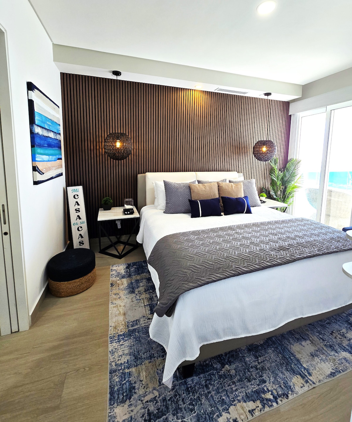 卧室-加大双人床，配备豪华床单、软垫床头板和床架、吊灯、2个大理石床头柜、2个多端口电涌保护器、全长镜子、隔音木板、电视和阳台。