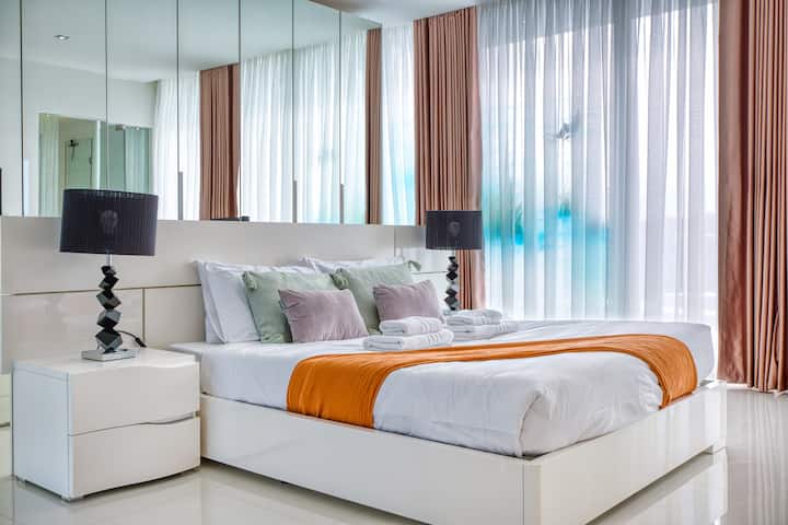 Уютна и елегантна спалня с първокласно спално бельо, меко осветление и прозорци от пода до тавана, предлагащи красиви гледки. Идеално за спокойни нощи в луксозен пентхаус Swieqi, идеален за двойки, семейства или групови почивки.