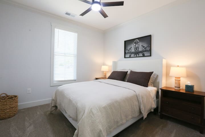 Queensize bed met luxe beddengoed en kast met bagage-opslag, extra beddengoed en kleerhangers.