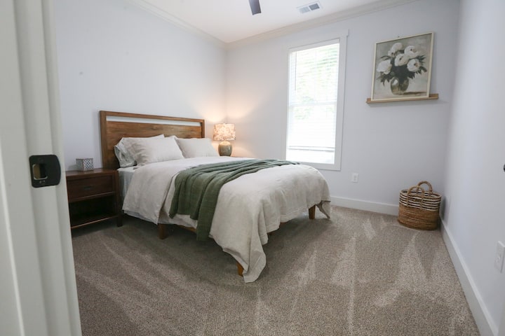 Slaapkamer met queensize bed, luxe beddengoed en kast met bagagehouder en hangers