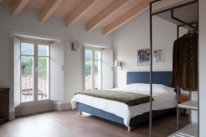 Голема спална соба со двоен кревет и фотелја, опремена со внимание и со поглед на езеро 