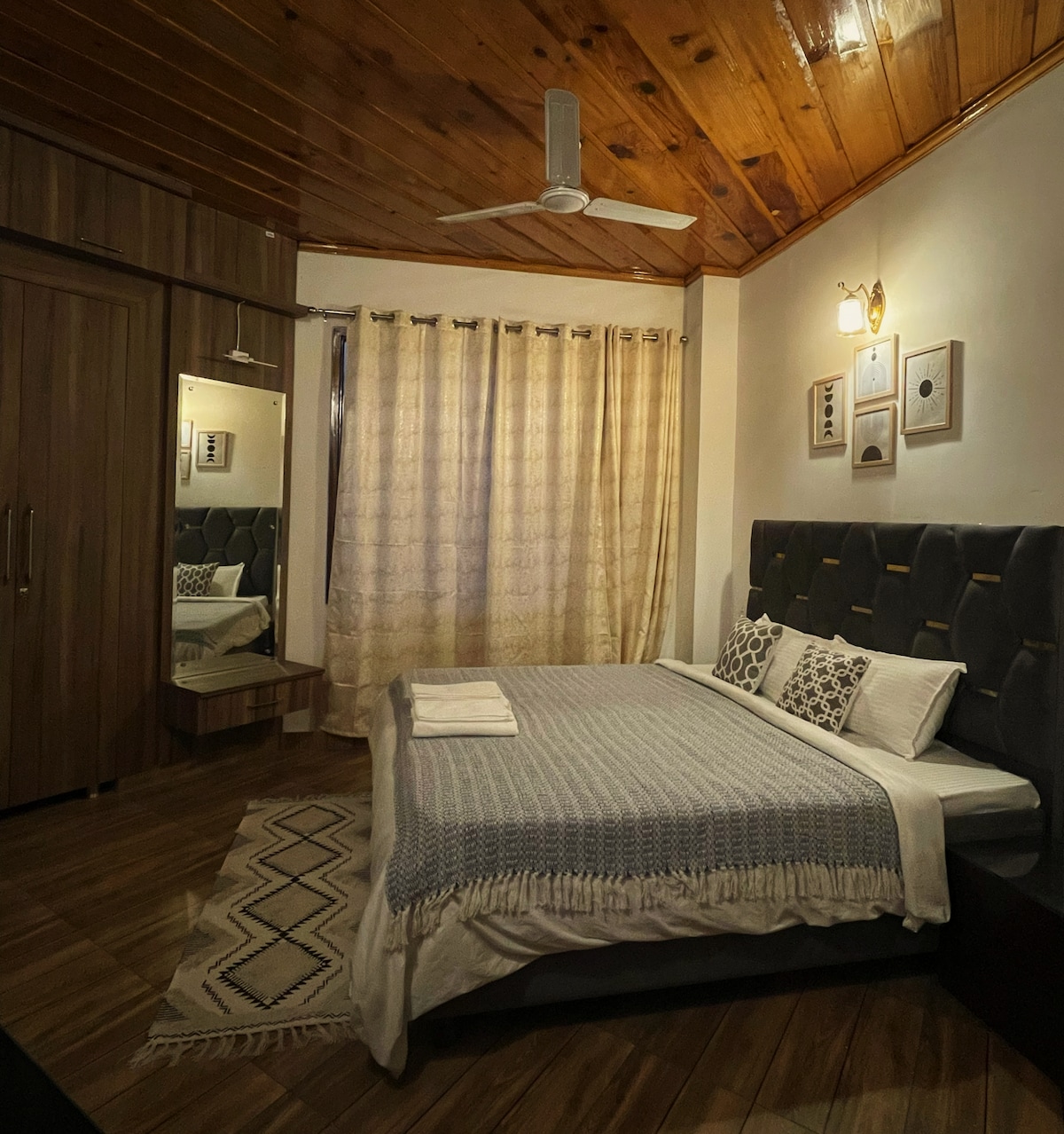Bedroom under wooden rafters — tufted headboard, mountain quiet