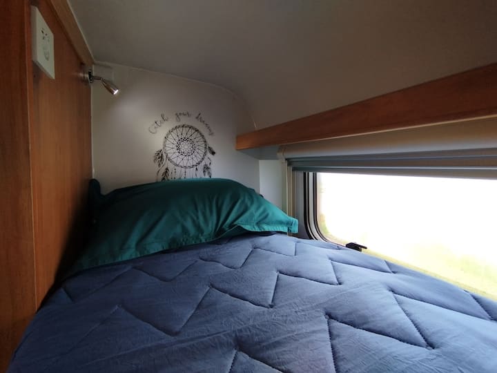 Upper single bed integrated in a bunk bed.