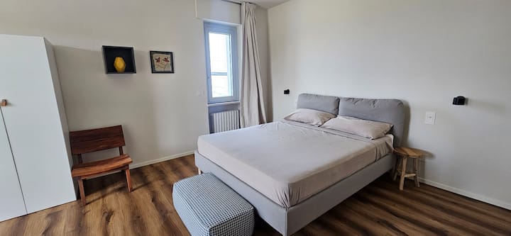 غرفة نوم كبيرة مع شرفة تطل على الريف والوادي وإطلالة جزئية على البحر 