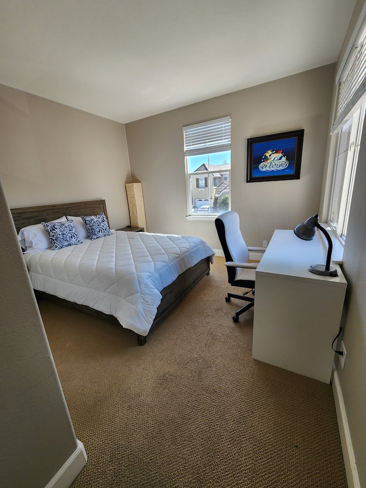 Dhomë gjumi në katin e sipërm me krevat dopio "queen", tavolinë pune, karrige të rehatshme zyre, abazhur tavoline dhe vepra arti argëtuese.