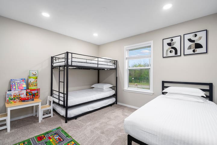 Este divertido dormitorio es perfecto para familias, con una litera doble, dos camas individuales más que incluyen una cama nido extraíble, una acogedora zona de juegos con juegos de mesa y una mesa para niños. Un televisor montado en la pared agrega mucha diversión para que los más pequeños descansen, jueguen y se relajen