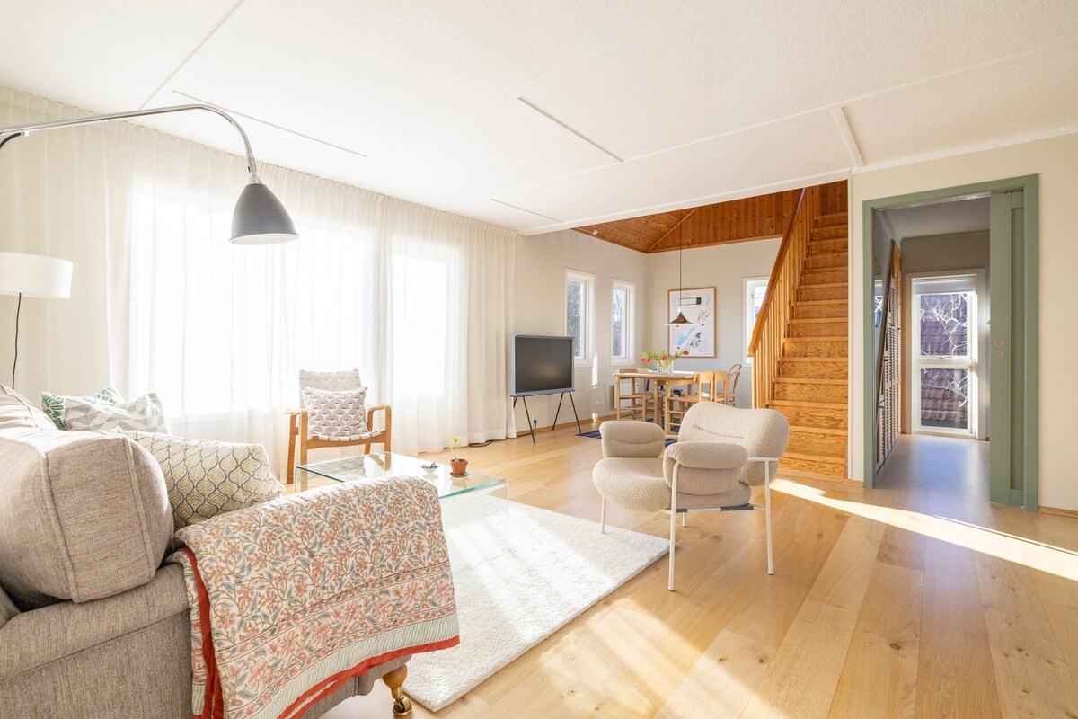 Príjemná a spoločenská obývacia izba/jedáleň s televízorom a systémom Sonos.