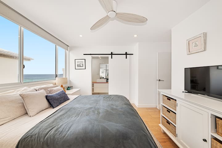Dormitorio principal con ropa de cama súper cómoda, vistas al mar y baño privado.